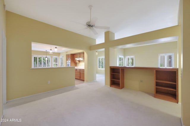 carpeted empty room featuring ceiling fan and a wealth of natural light