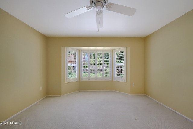 carpeted spare room featuring ceiling fan