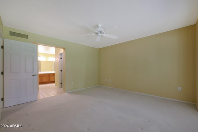 empty room with ceiling fan and light carpet