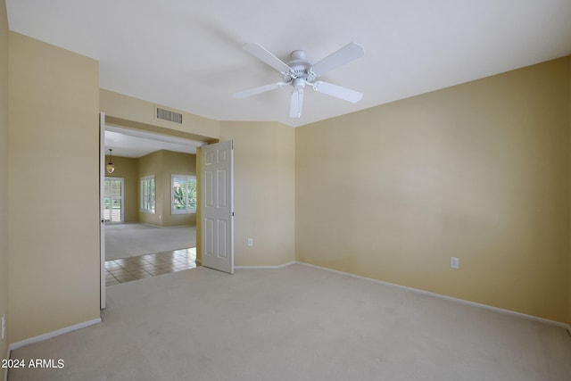 carpeted spare room featuring ceiling fan