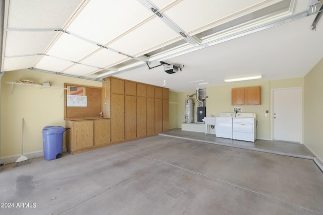 garage with sink, a garage door opener, washing machine and clothes dryer, and water heater