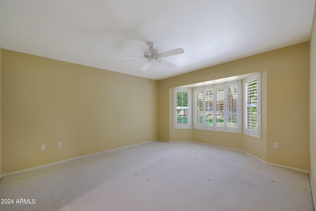 carpeted spare room featuring ceiling fan