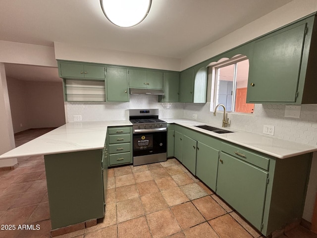 1705 E 6th St, Douglas, AZ 85607 - kitchen with stainless steel gas stove, a sink, under cabinet range hood, green cabinetry, and decorative backsplash