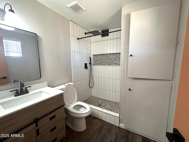1705 E 6th St, Douglas, AZ 85607 - bathroom featuring toilet, a tile shower, wood finished floors, and vanity