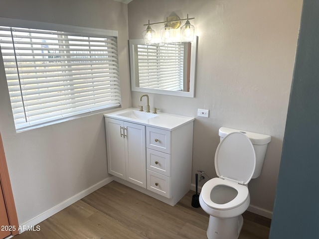 1705 E 6th St, Douglas, AZ 85607 - bathroom featuring wood finished floors, toilet, vanity, and baseboards