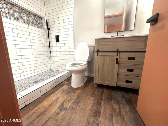 1705 E 6th St, Douglas, AZ 85607 - bathroom with toilet, hardwood / wood-style floors, a tile shower, and vanity