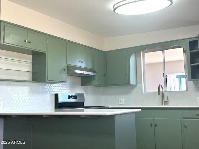 1705 E 6th St, Douglas, AZ 85607 - kitchen with green cabinetry, under cabinet range hood, electric stove, decorative backsplash, and a sink