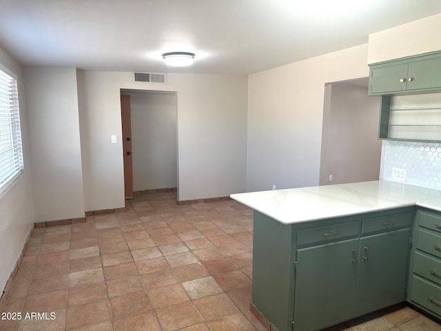 1705 E 6th St, Douglas, AZ 85607 - kitchen featuring green cabinets, a peninsula, baseboards, and light countertops