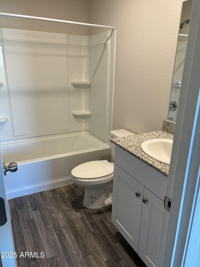 full bathroom with shower / bathing tub combination, hardwood / wood-style floors, vanity, and toilet