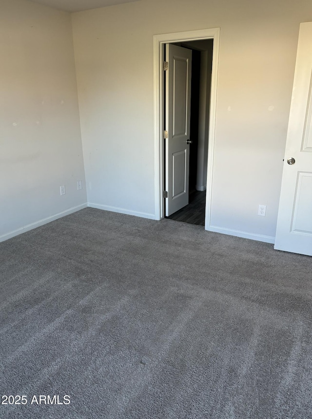 unfurnished room with dark carpet