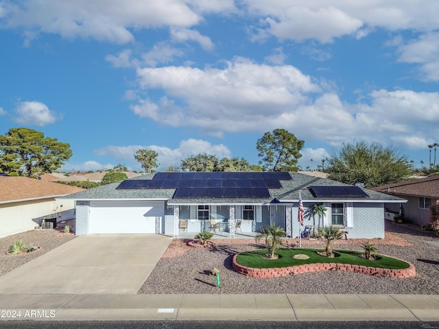 ranch-style house with solar panels and a garage