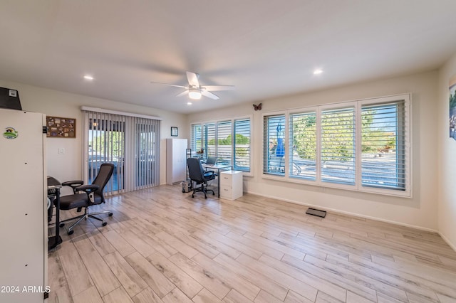 home office with light wood-type flooring and ceiling fan