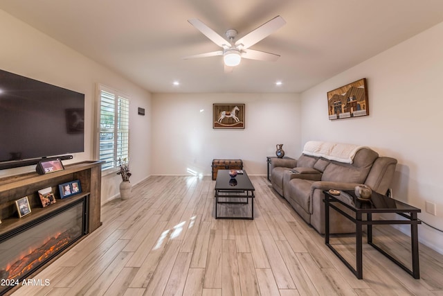 living room featuring ceiling fan and light hardwood / wood-style floors