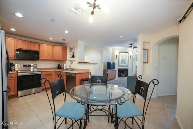 kitchen featuring ceiling fan, light tile patterned floors, and black appliances