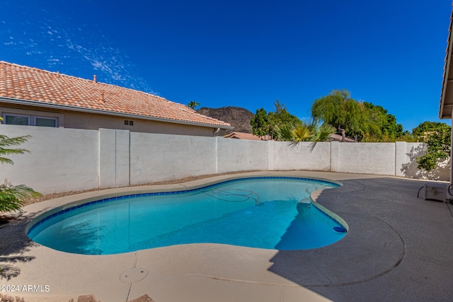 view of swimming pool featuring a mountain view and a patio area