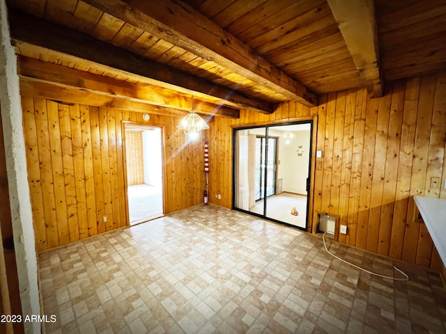 tiled spare room featuring wooden walls, beam ceiling, and wooden ceiling