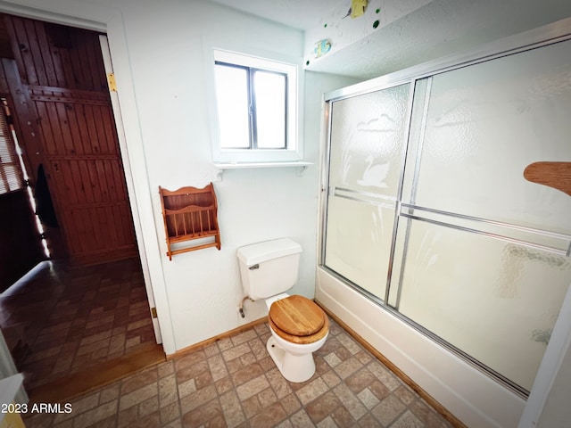 bathroom with toilet, bath / shower combo with glass door, and tile flooring