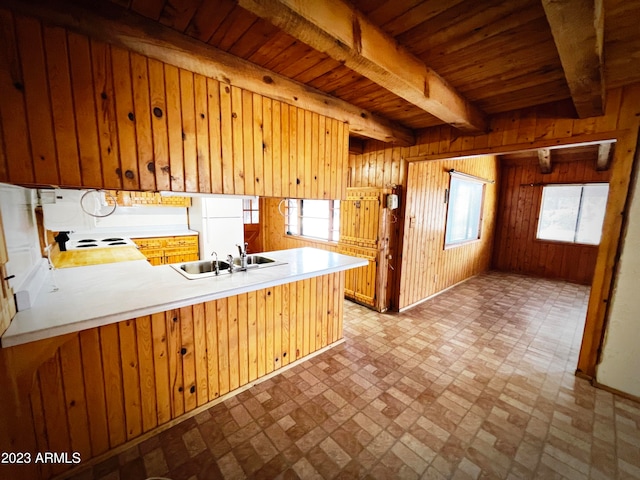 kitchen featuring wooden ceiling, kitchen peninsula, a wealth of natural light, beamed ceiling, and sink