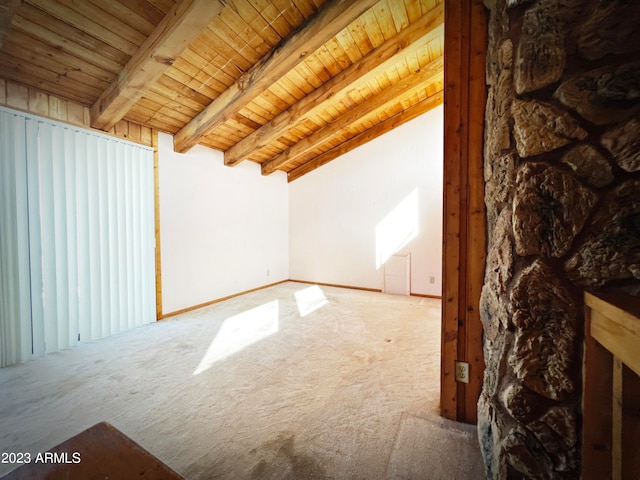 additional living space with lofted ceiling with beams, wooden ceiling, and carpet