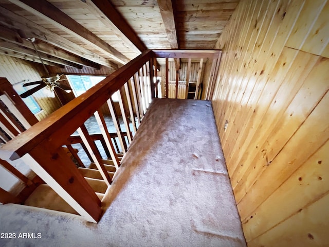 staircase with ceiling fan and beamed ceiling