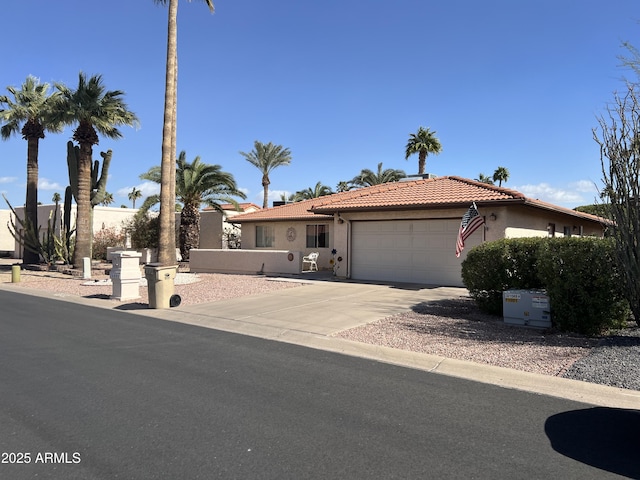 view of front facade with a tile roof, driveway, stucco siding, and an attached garage