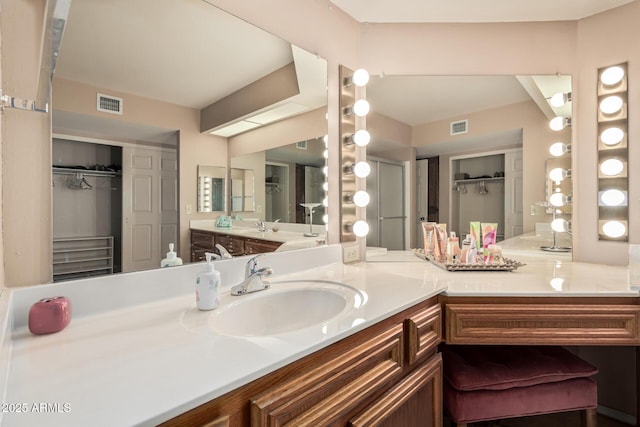 bathroom with visible vents, a spacious closet, and vanity
