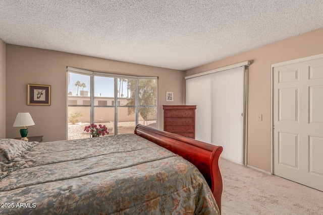 bedroom with a closet, carpet floors, access to exterior, and a textured ceiling