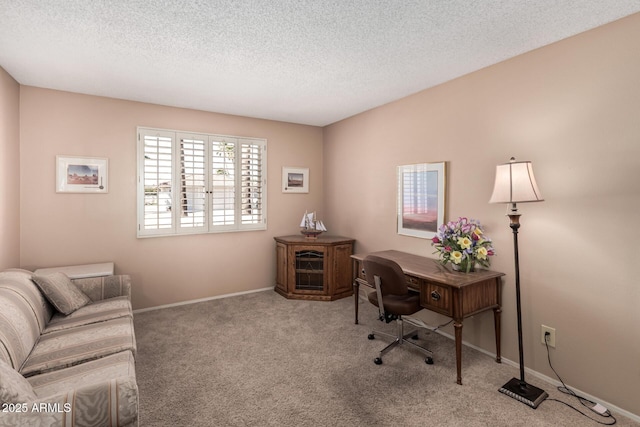 carpeted office featuring baseboards and a textured ceiling