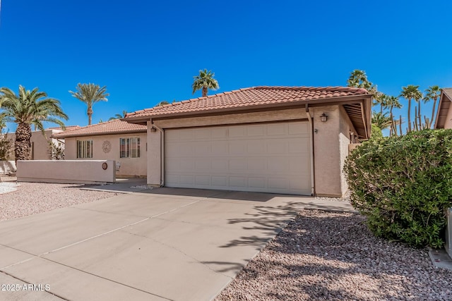 view of front of house featuring stucco siding, driveway, a garage, and a tiled roof