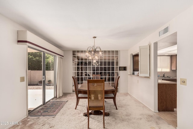 dining space featuring visible vents, an inviting chandelier, and light colored carpet