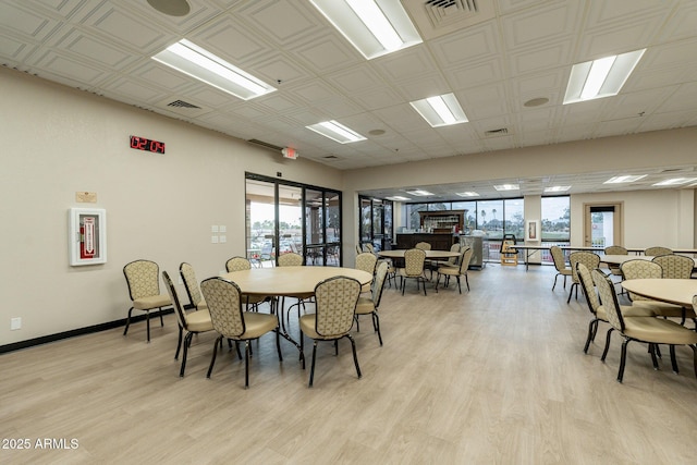 dining area with light wood finished floors, baseboards, and visible vents