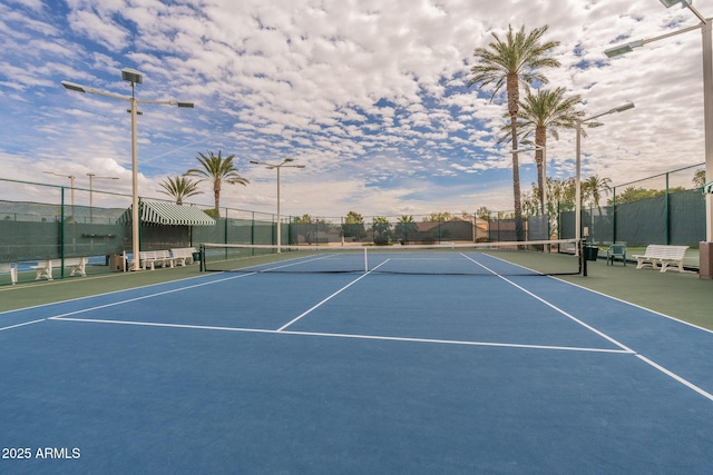 view of tennis court featuring fence