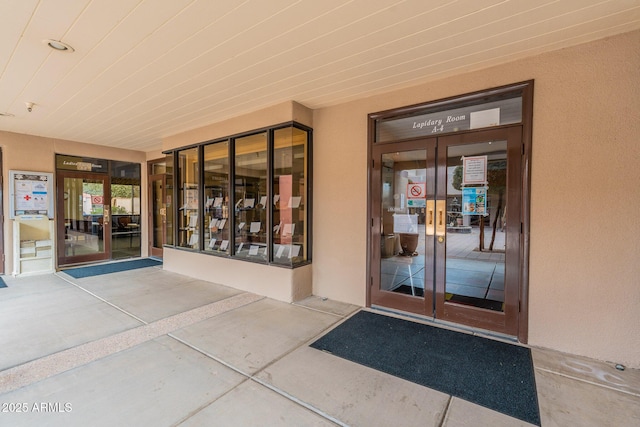 property entrance featuring french doors and stucco siding