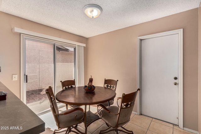 dining room featuring light tile patterned floors and a textured ceiling