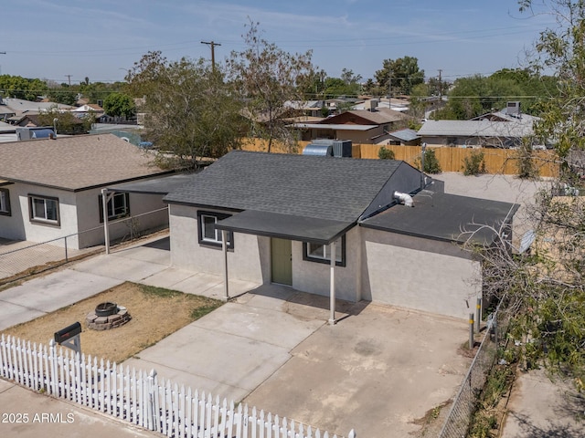 826 S Drew St, Mesa, AZ 85210 - view of front facade with an outdoor fire pit, a shingled roof, a fenced backyard, and stucco siding