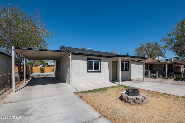 826 S Drew St, Mesa, AZ 85210 - view of front of property featuring stucco siding, an outdoor fire pit, driveway, and a carport