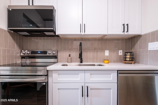 826 S Drew St, Mesa, AZ 85210 - kitchen featuring appliances with stainless steel finishes, range hood, backsplash, and white cabinets