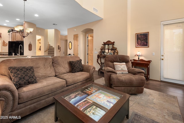 living room featuring visible vents, wood finished floors, recessed lighting, arched walkways, and stairs