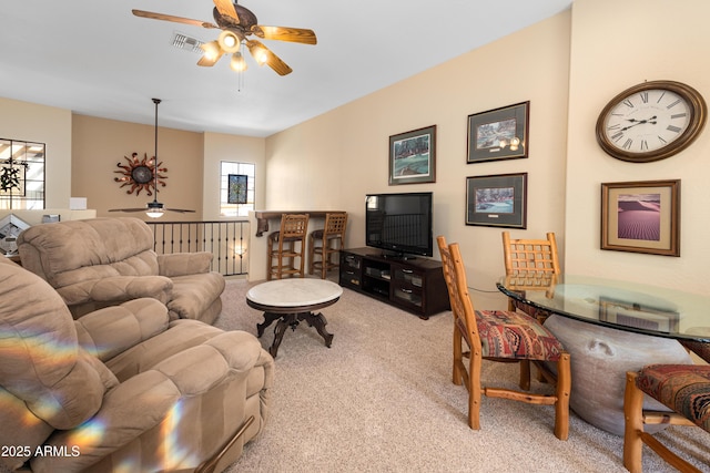 living room with carpet flooring, visible vents, and a ceiling fan