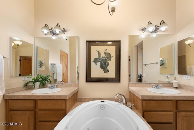 bathroom with a tub with jets, two vanities, and a sink