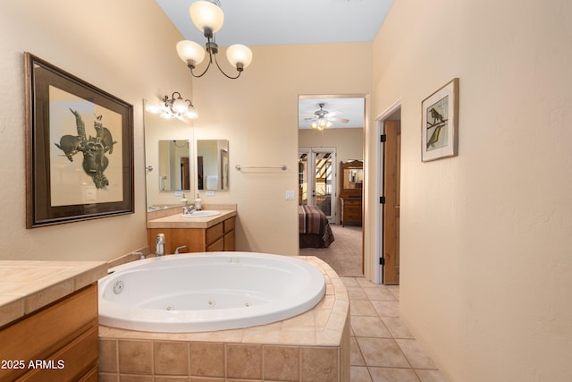 full bathroom with ceiling fan with notable chandelier, a jetted tub, ensuite bath, tile patterned flooring, and vanity