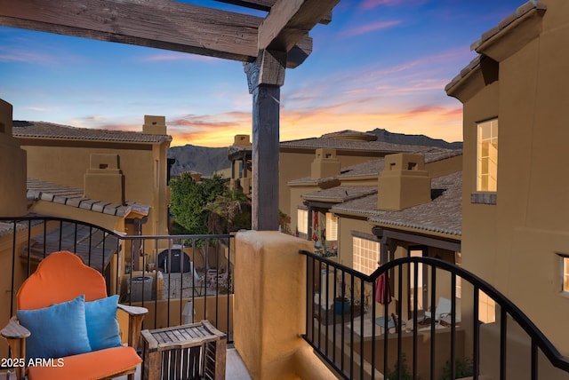 balcony at dusk featuring a mountain view