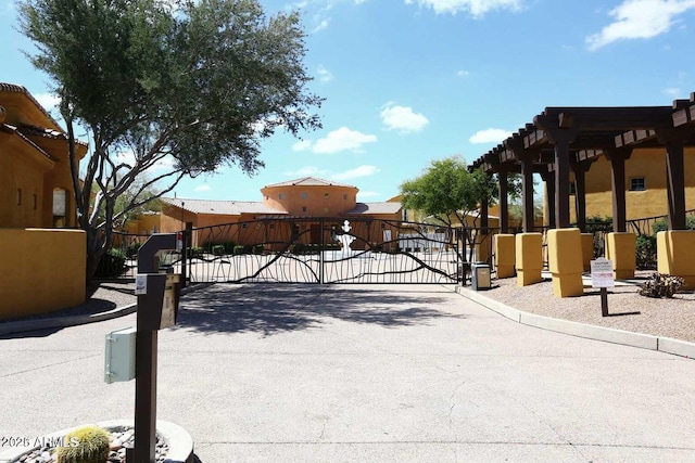 view of street featuring curbs, a gated entry, and a gate