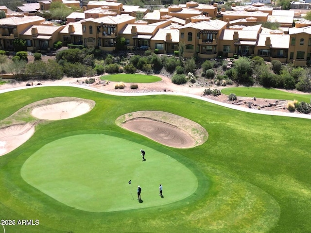 view of home's community featuring a residential view, a yard, and view of golf course