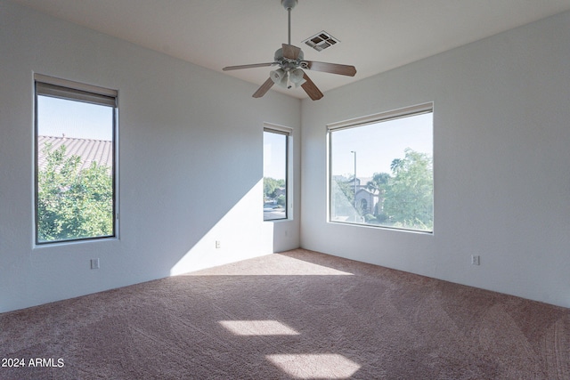 carpeted empty room with a healthy amount of sunlight and ceiling fan