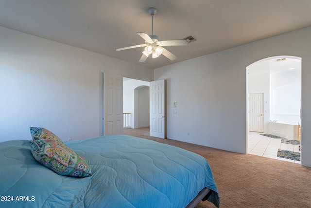 bedroom featuring connected bathroom, light carpet, and ceiling fan