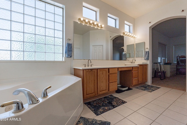 bathroom featuring tile patterned flooring, vanity, and a tub to relax in