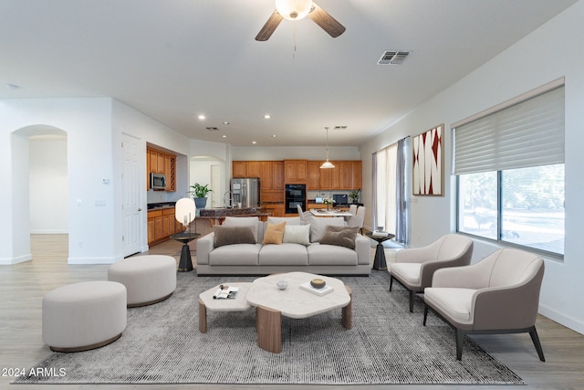 living room featuring ceiling fan and light hardwood / wood-style floors