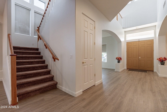 entrance foyer with a towering ceiling and light hardwood / wood-style floors