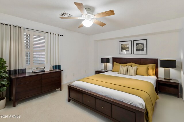 bedroom with ceiling fan, light colored carpet, and visible vents